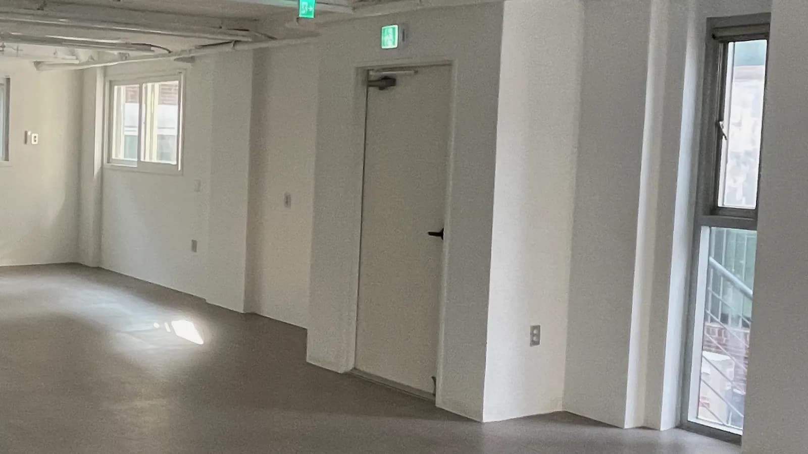 기둥과 비상구가 보이는 빈 공간 · 병원 인테리어 비용 참고 사진