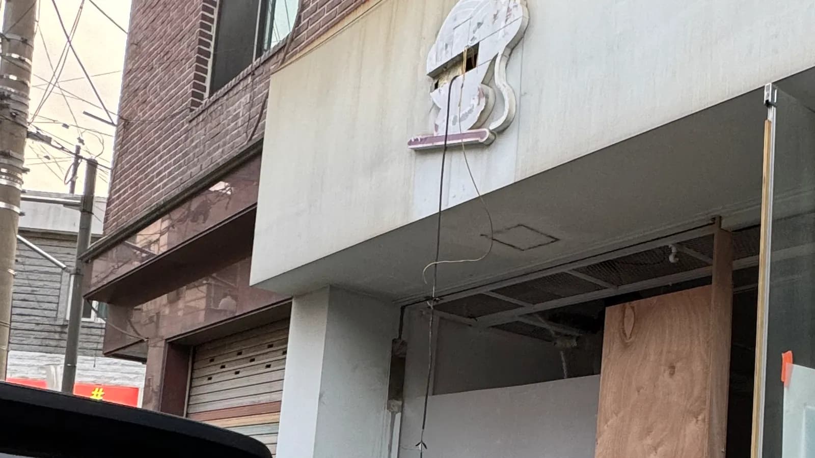 출입문을 떼고 합판을 댄 채 폐기물 마대가 나온 1층 점포 입구 · 점포철거비 신청 순서 참고 사진