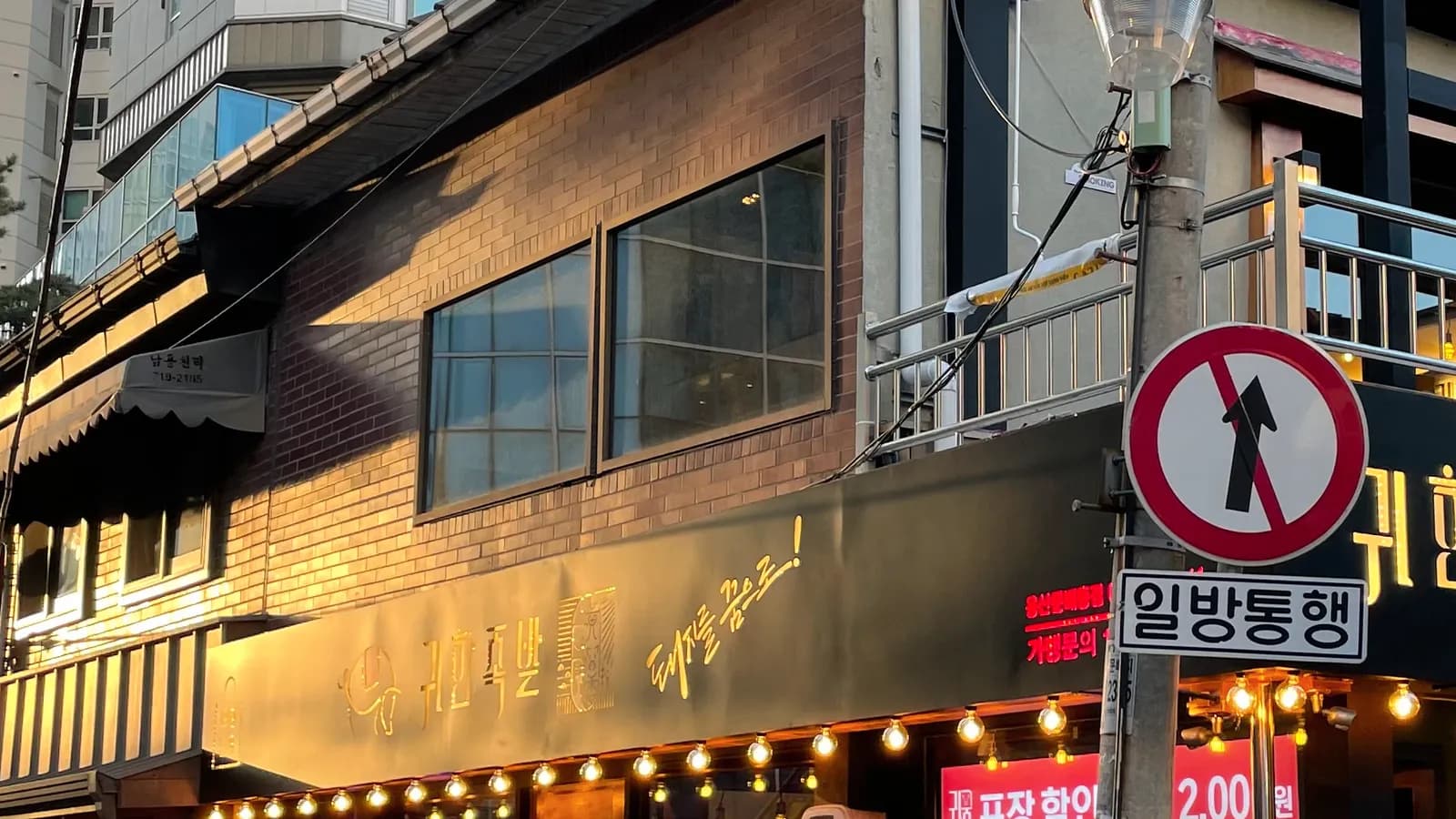 간판이 달린 상가 건물 외관 근접 컷 · 상가 통유리 시공비 가이드 수록 사진
